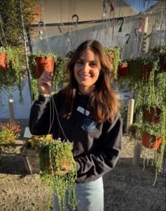 Esmeralda Lopez standing among vibrant succulents at California Greenhouses